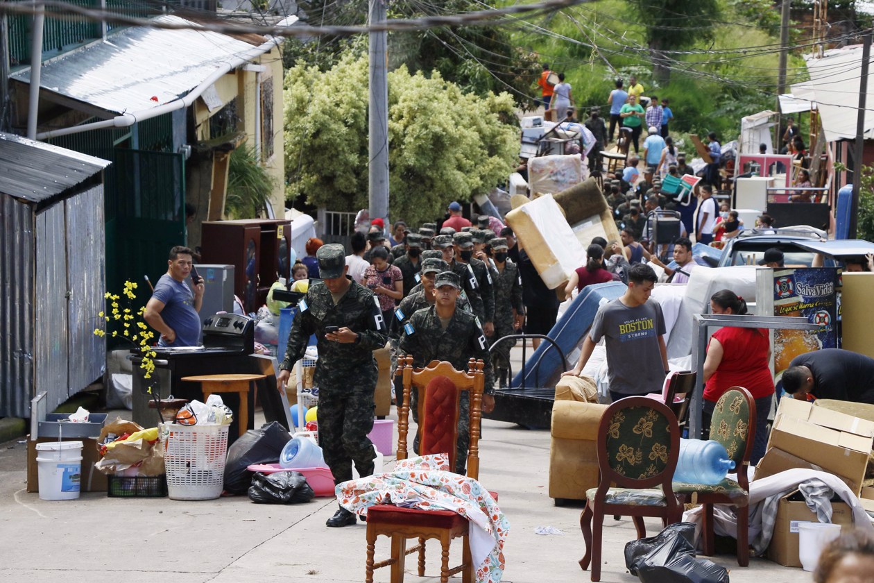 Personas tratan de rescatar sus pertenencias tras presentarse fallas estructurales en sus casas por las fuertes lluvias.