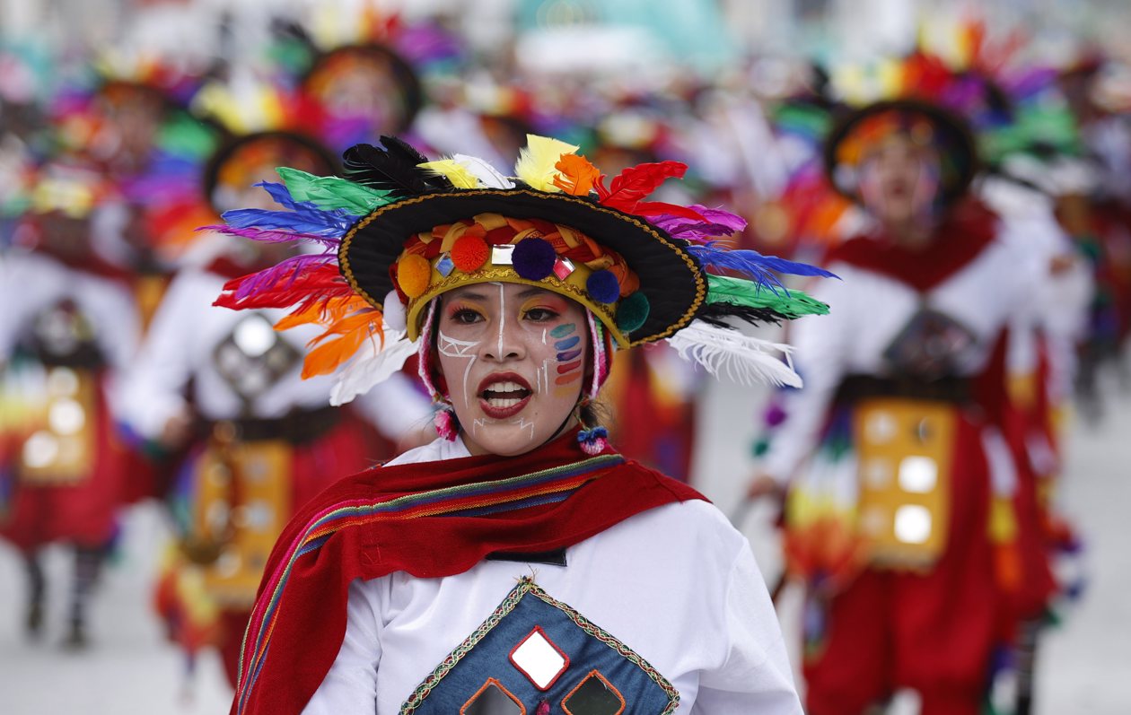 Personas participan en el desfile de los colectivos coreográficos en tributo a la Madre Tierra durante el Carnaval de Negros y Blancos.