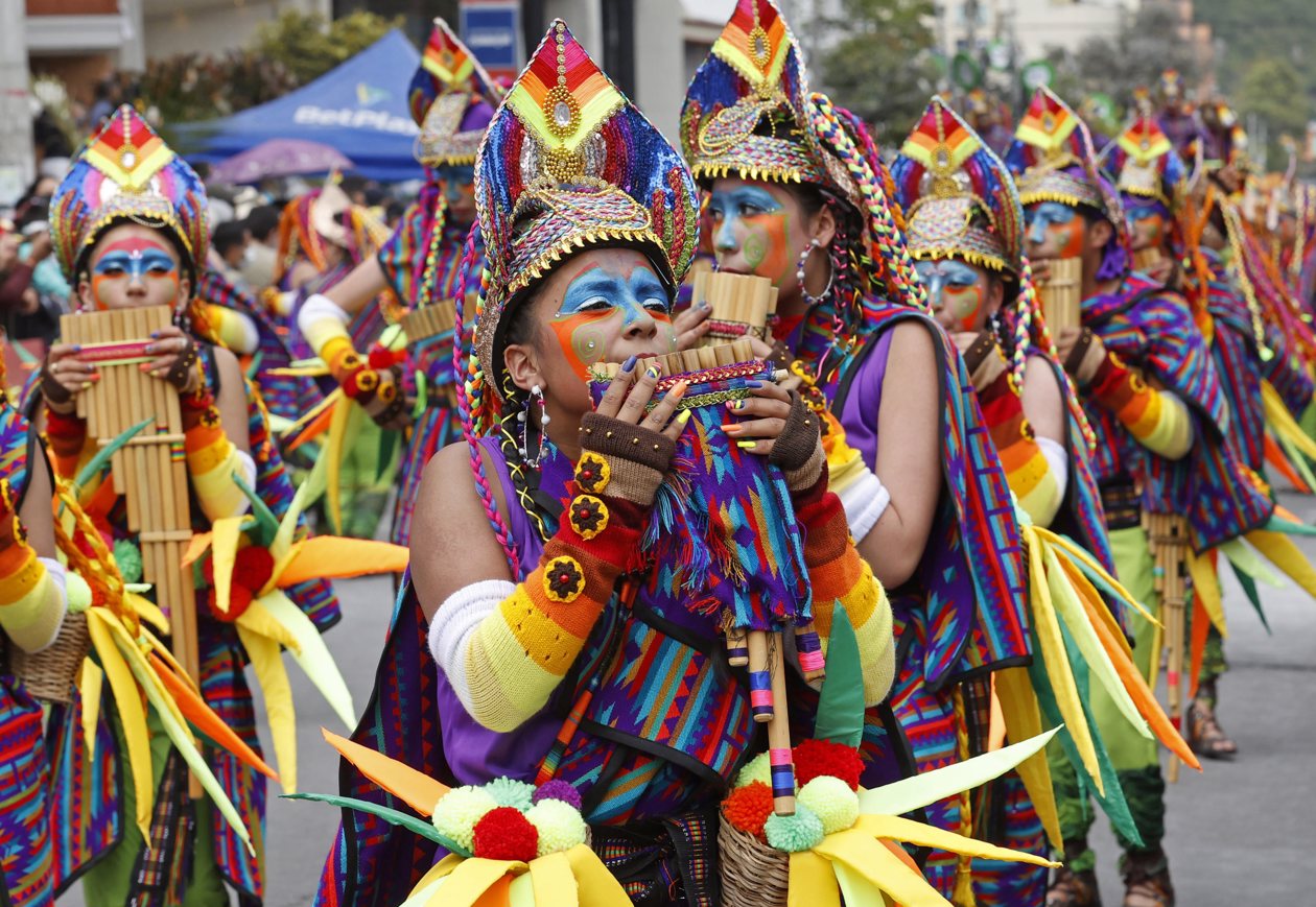 Personas participan en el desfile de los colectivos coreográficos en tributo a la Madre Tierra durante el Carnaval de Negros y Blancos.