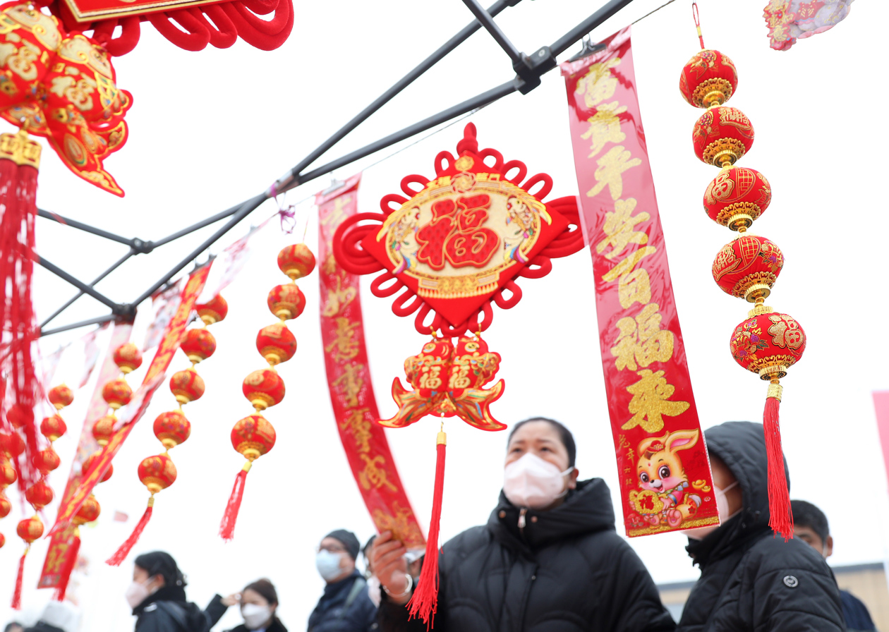 Compradores miran productos tradicionales chinos que se ofrecen a la venta antes de las celebraciones del Año Nuevo Lunar. 