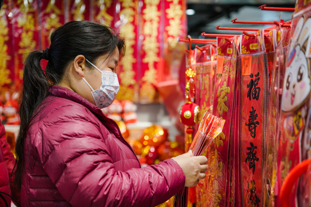 Compradores miran productos tradicionales chinos que se ofrecen a la venta antes de las celebraciones del Año Nuevo Lunar. 