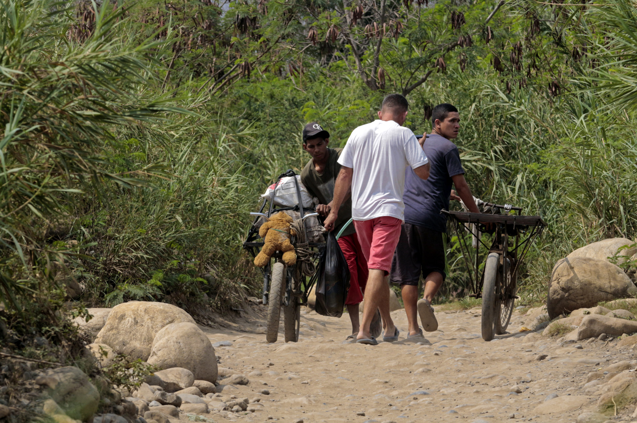 Personas cargan mercancías a través de las trochas que conectan a Colombia con Venezuela.