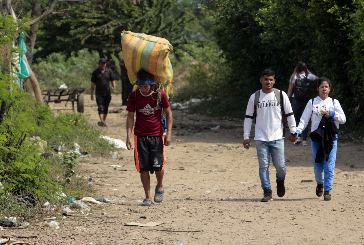 Personas cargan mercancías a través de las trochas que conectan a Colombia con Venezuela.