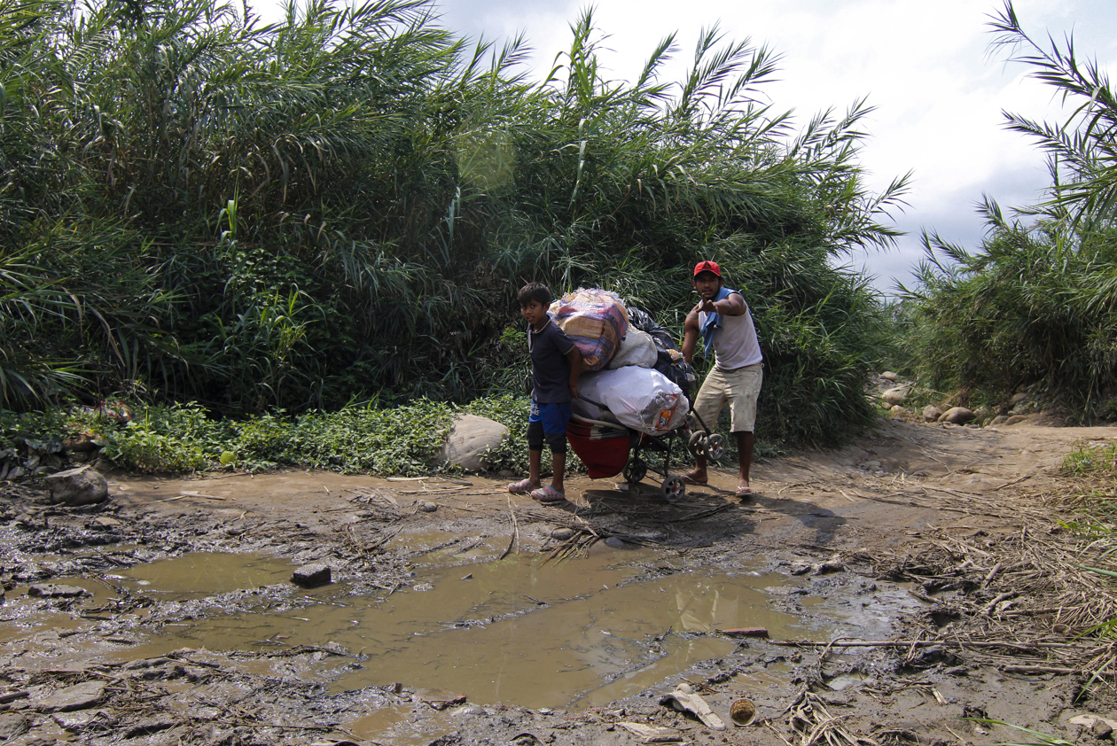 Personas cargan mercancías a través de las trochas que conectan a Colombia con Venezuela.