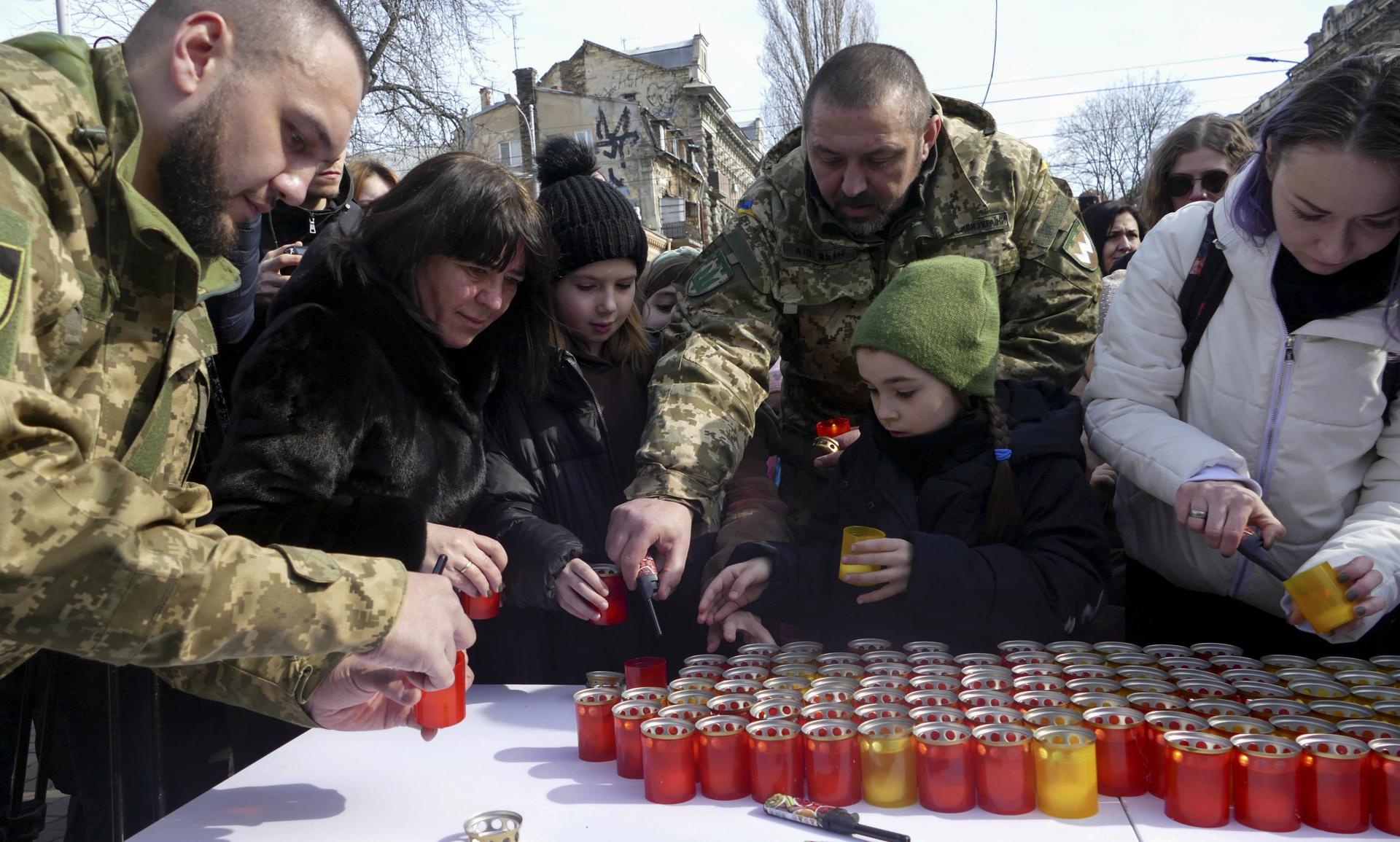 Familiares y amigos de los soldados ucranianos caídos de Odesa encienden velas en el primer año de la invasión rusa.