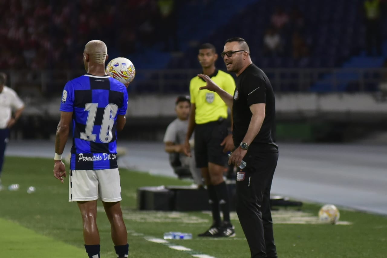 Delvin Alfonso recibiendo instrucciones del banco.