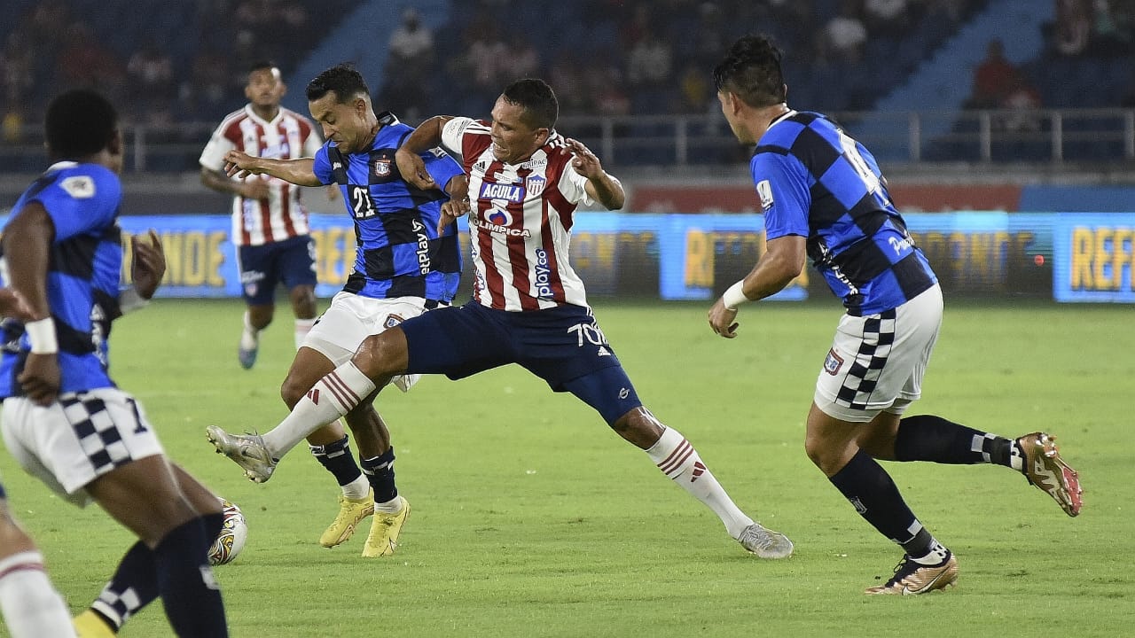 Carlos Bacca luchando el balón entre varios rivales.