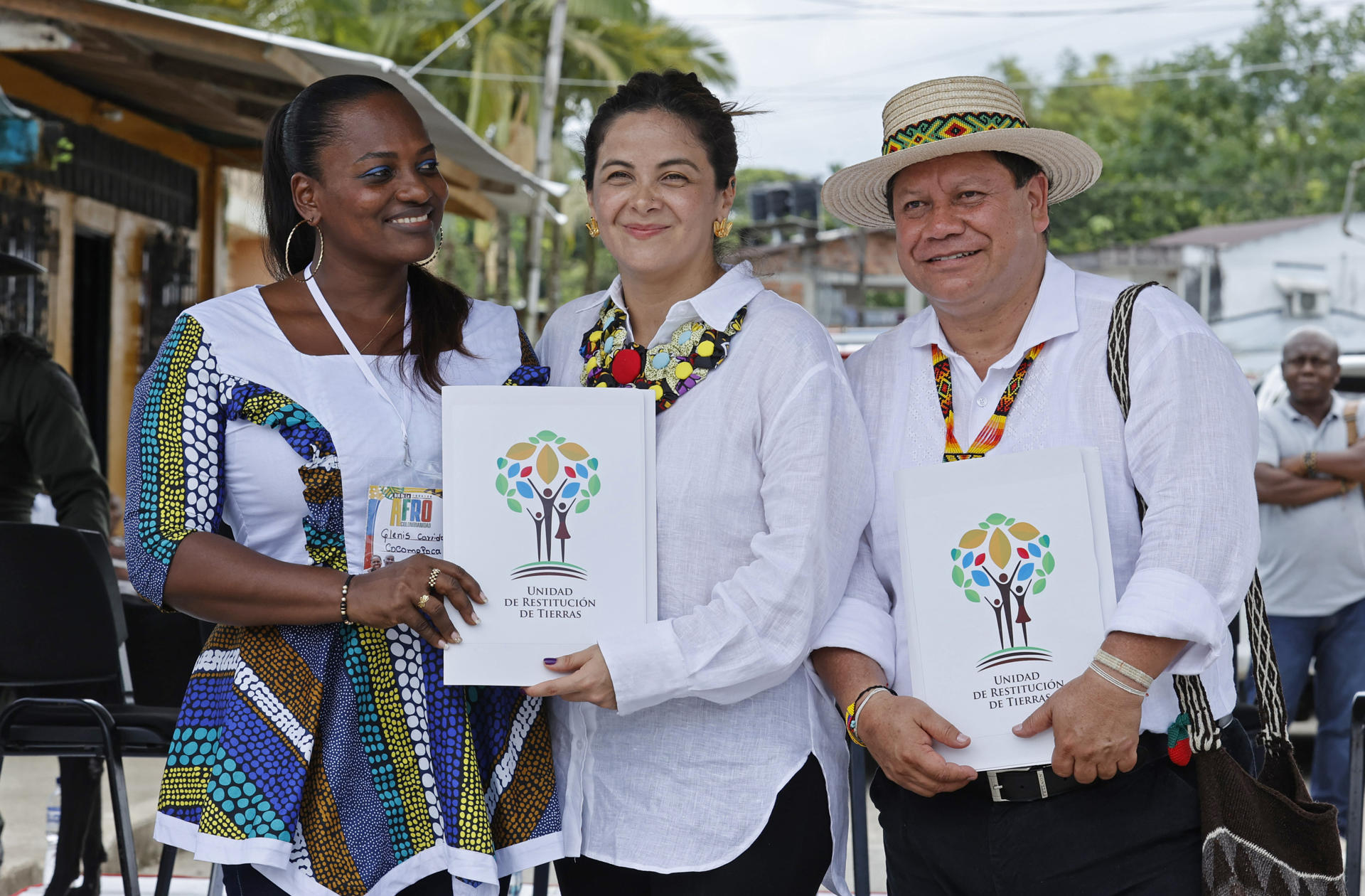 La representante legal de Cocomopoca Glenis Garrido (i), la Ministra de Agricultura Jhenifer Mojica (c) y el Director general de la Unidad de Restitución de Tierras, Giovani Yule.