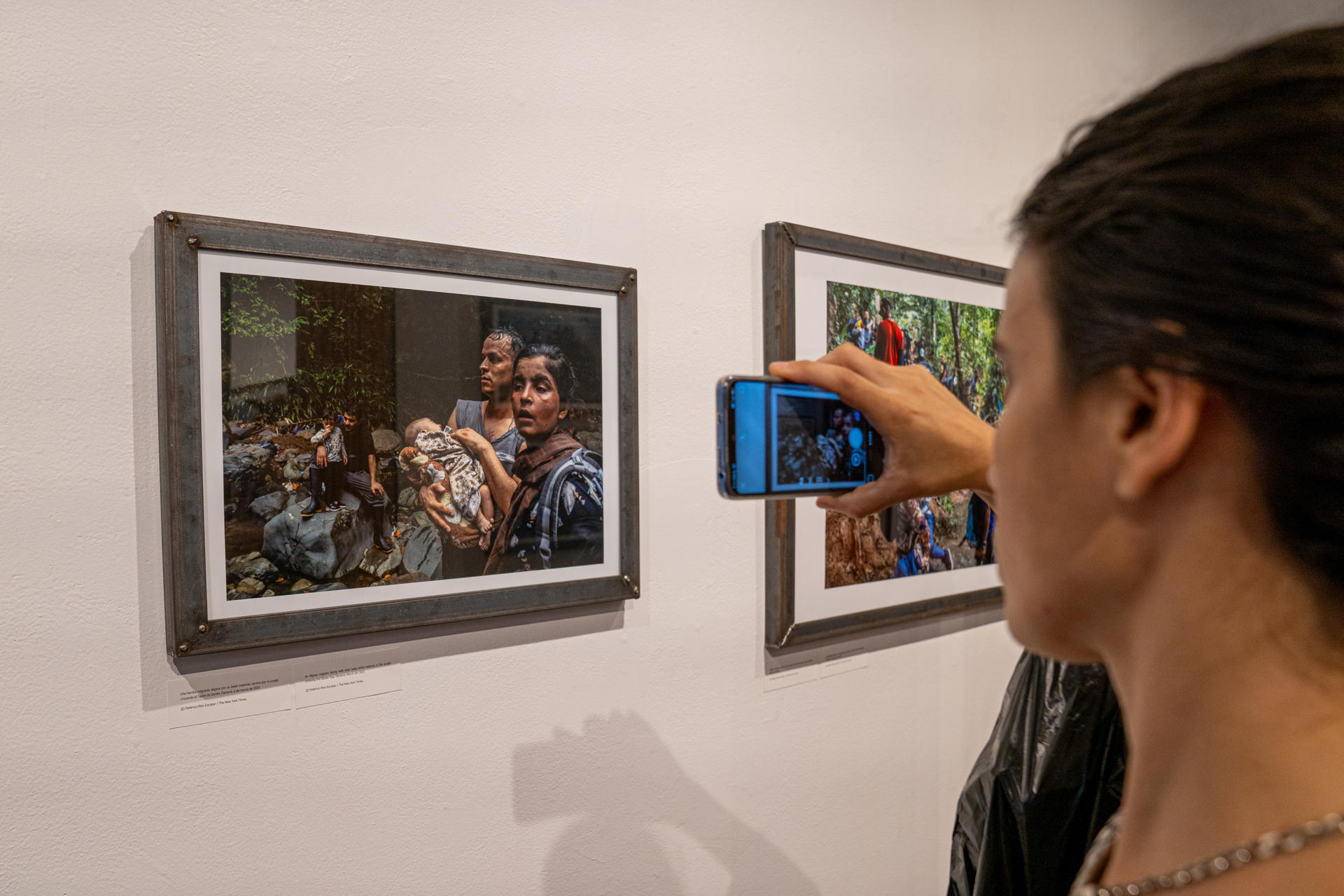 Habitante observa la exposición de fotografía.