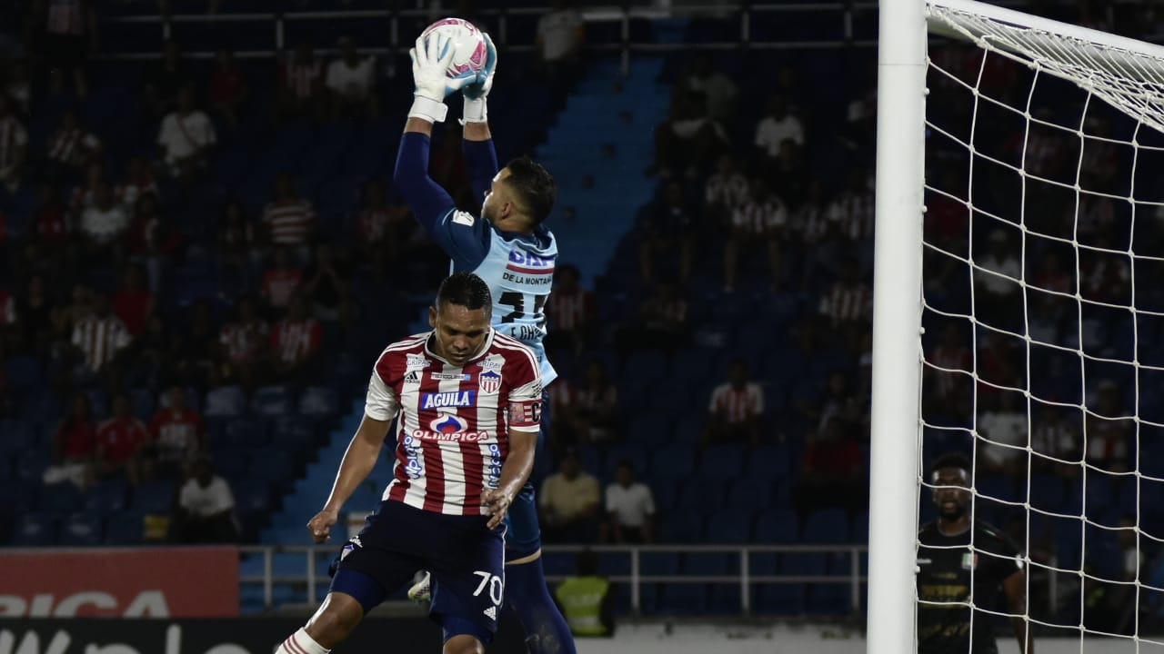 Éder Chaux, gran figura del Once Caldas, se cuelga de la pelota ante el asedio de Carlos Bacca. 