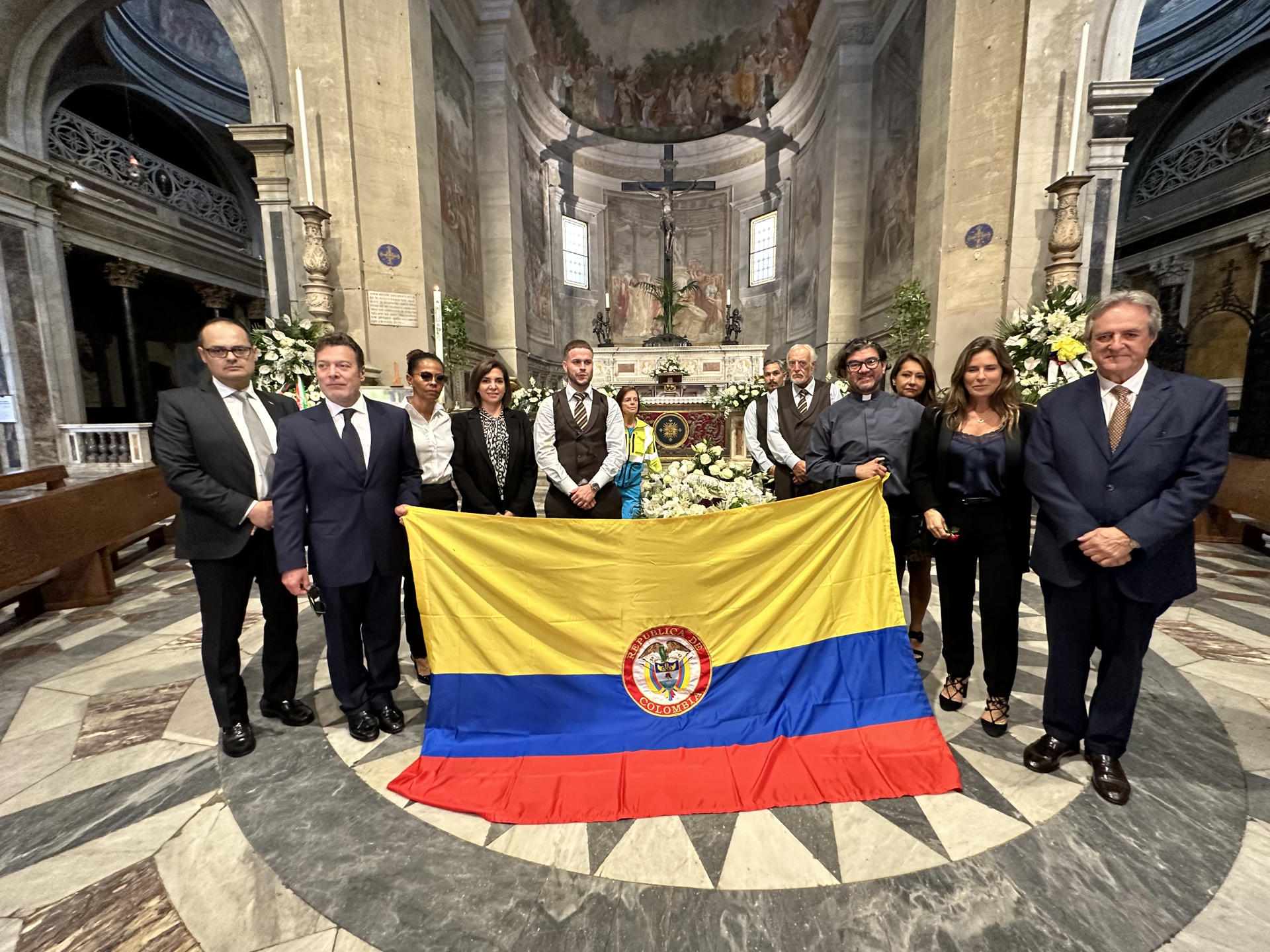 Hija de Fernando Botero, Lina Botero, amigos, familiares y autoridades con la bandera de Colombia.