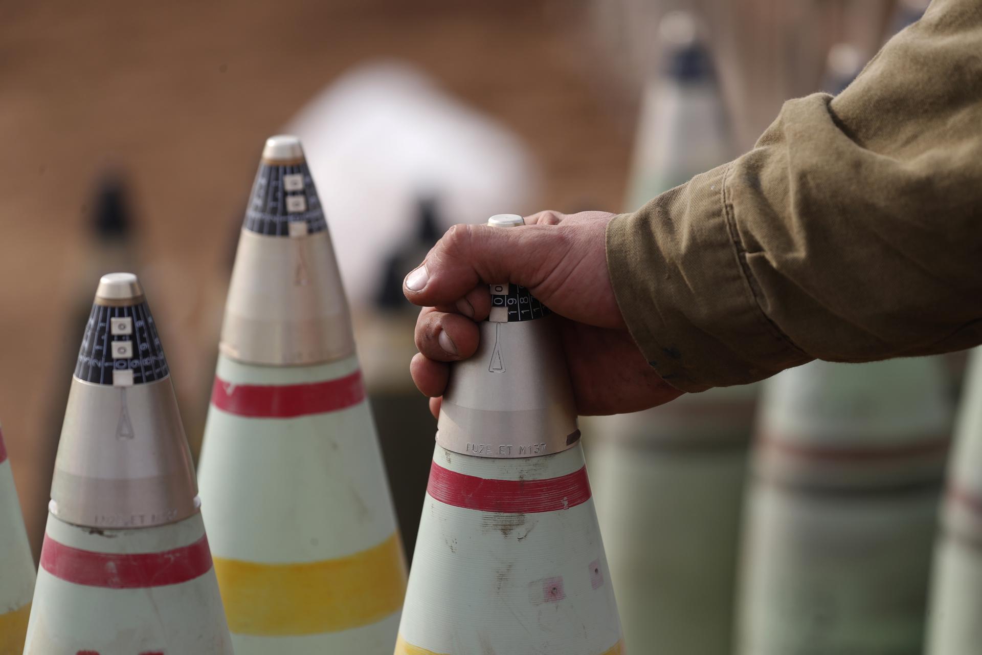 Un soldado de artillería israelí revisa proyectiles en la frontera con Gaza.