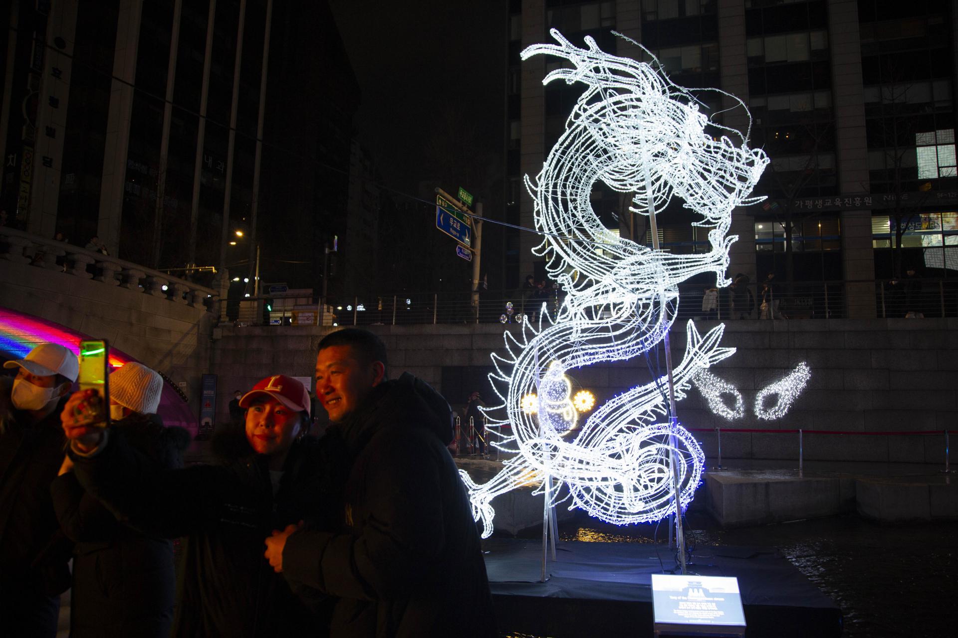 En Seúl, Corea del Sur, las personas se tomaron fotos con una figura iluminada de un dragón azul, que es el animal del año según el zodiaco chino.