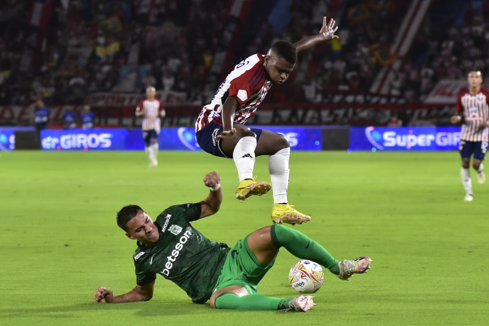 Déiber Caicedo salta ante el cierre de Juan José Arias, defensa de Nacional. 