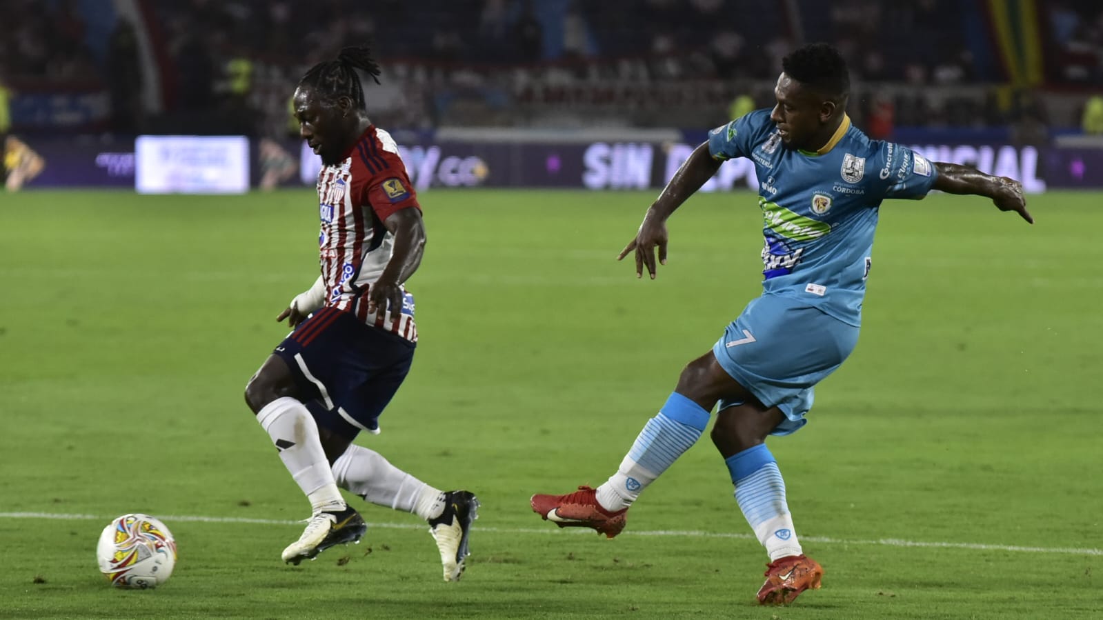 Yimmi Chará, autor del tercer gol del Junior, deja en el camino a Pablo Rojas. 