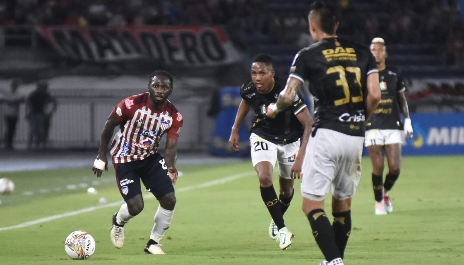 Yimmi Chará intenta escaparse entre Alejandro García y Juan Pablo Patiño.