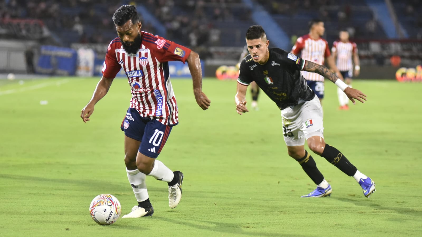 'Cariaco' González es perseguido por Juan Pablo Patiño.