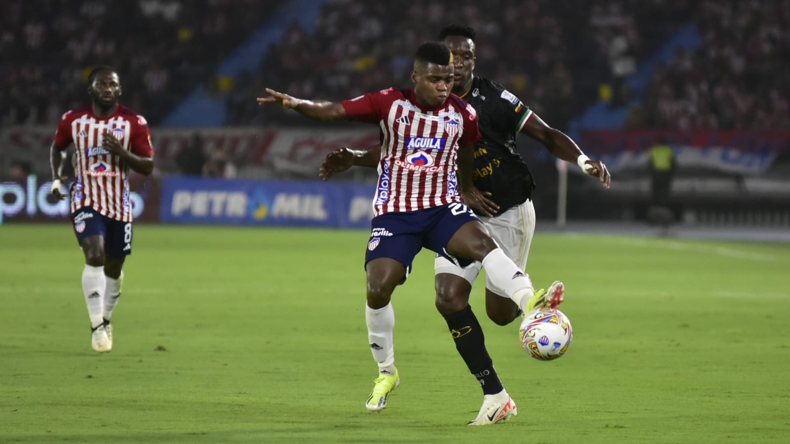 Déiber Caicedo protege el balón ante la marca de Yonatan Murillo. 