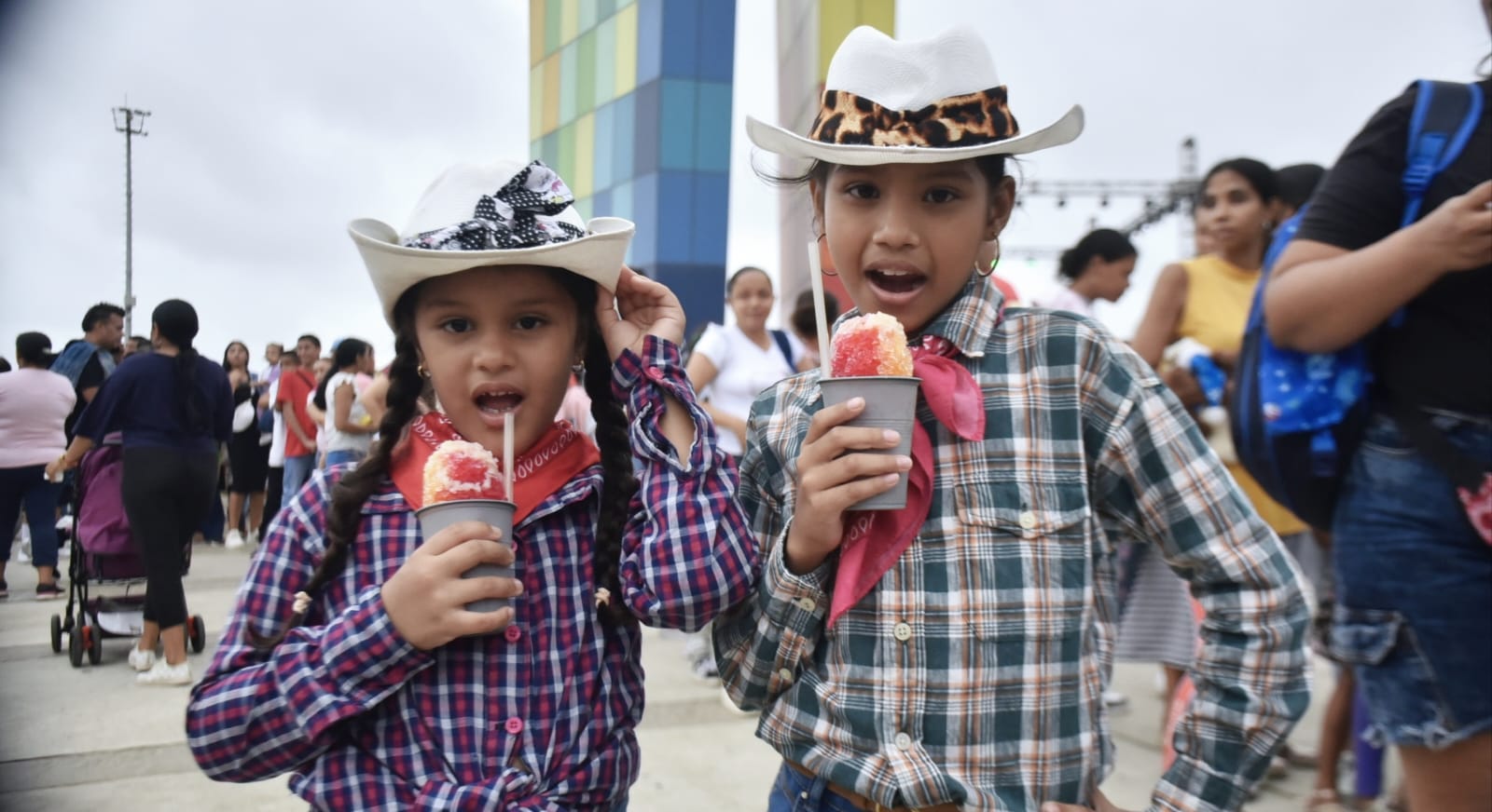 Dos niños comiendo raspao. 