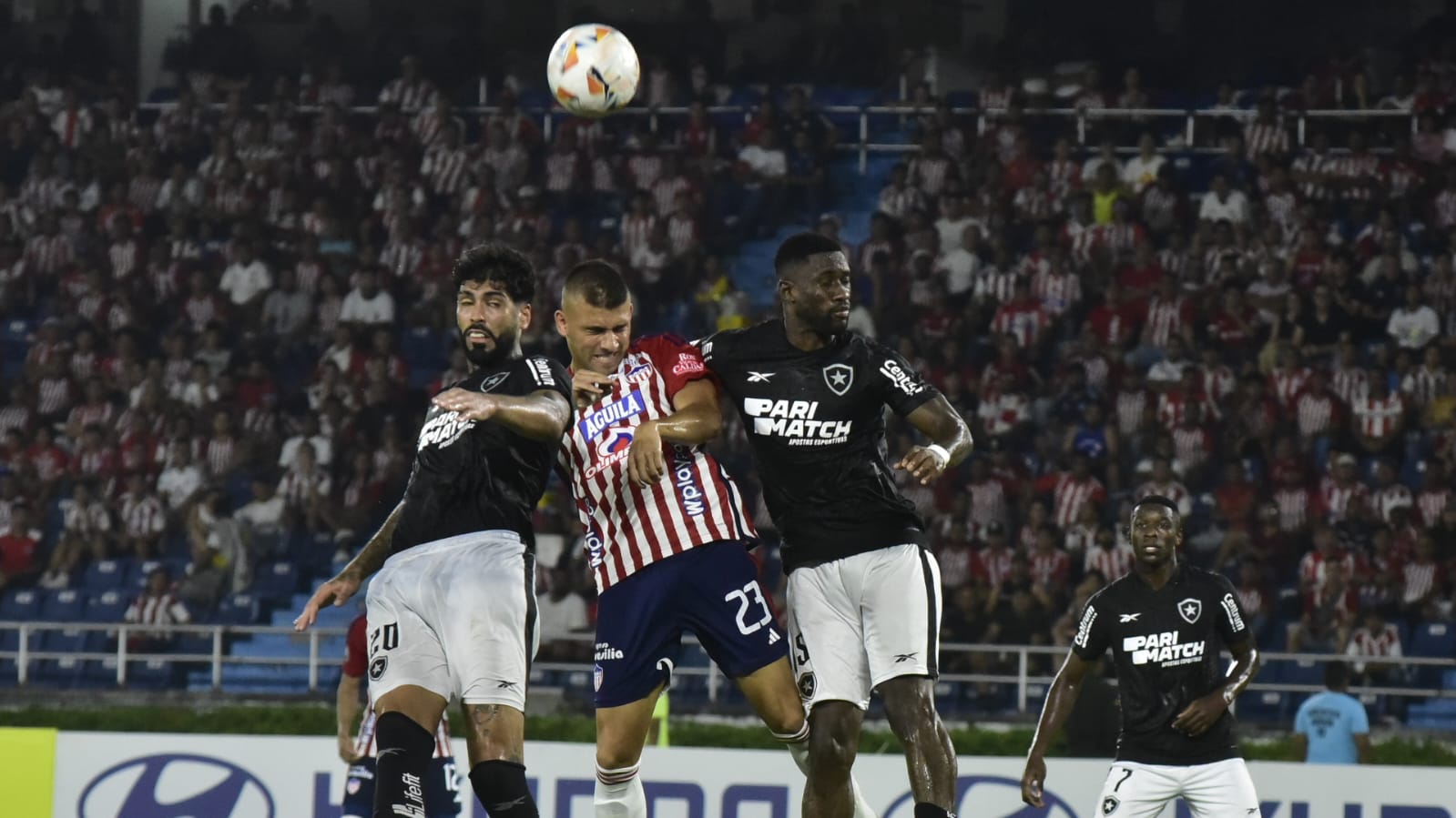 Steven 'Titi' Rodríguez salta a pelear la pelota con Alexander Barboza y Bastos. 