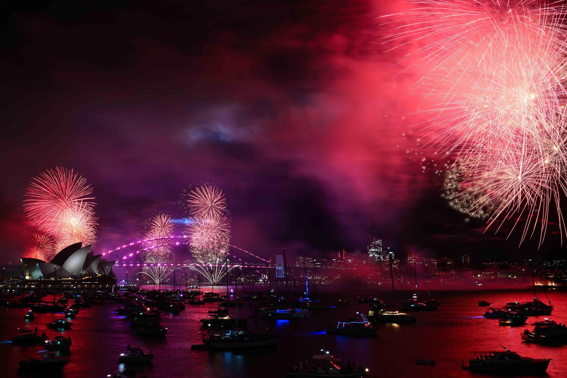 Fuegos artificiales iluminan el cielo sobre la Ópera de Sídney y el Puente del Puerto como parte de las primeras celebraciones.