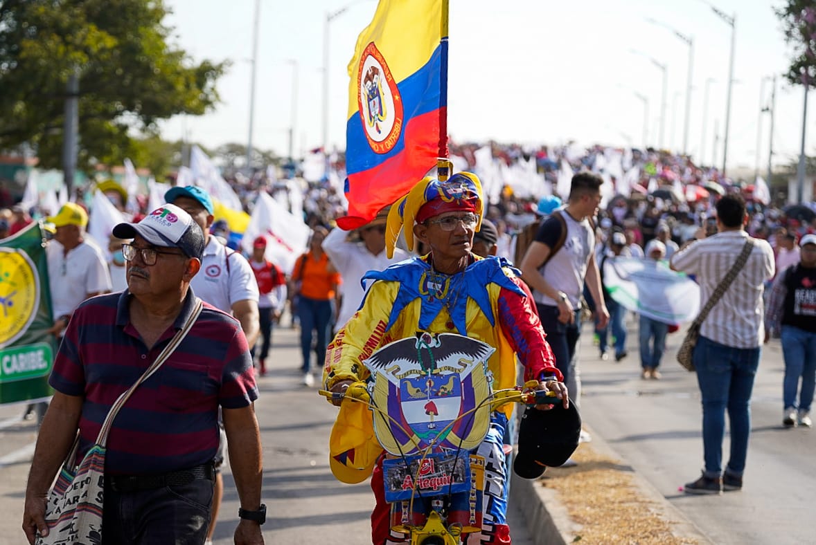 Un hombre vestido con los colores de Colombia en bicicleta durante la marcha. 