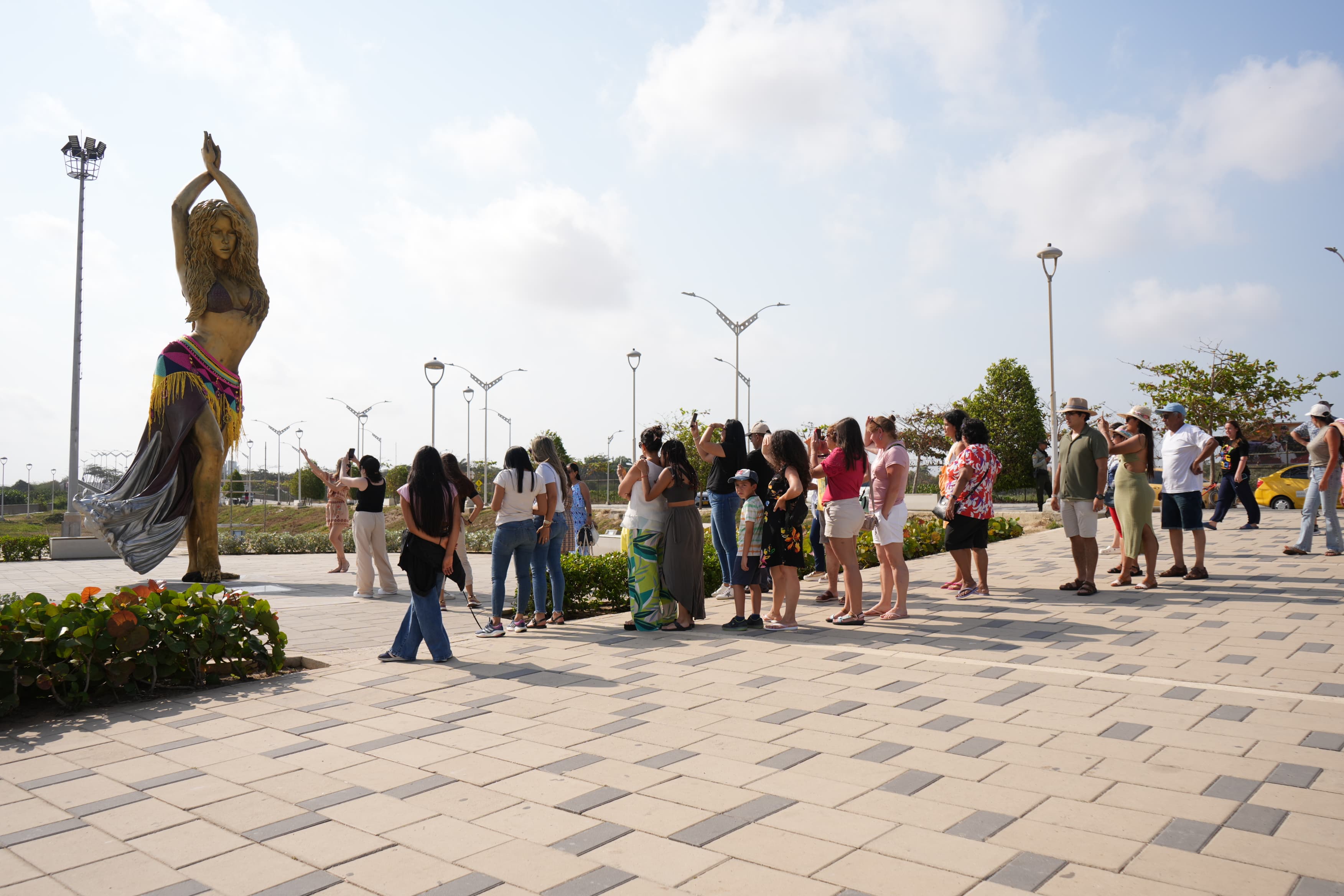 Turistas en la estatua de Shakira en el Malecón del Río.
