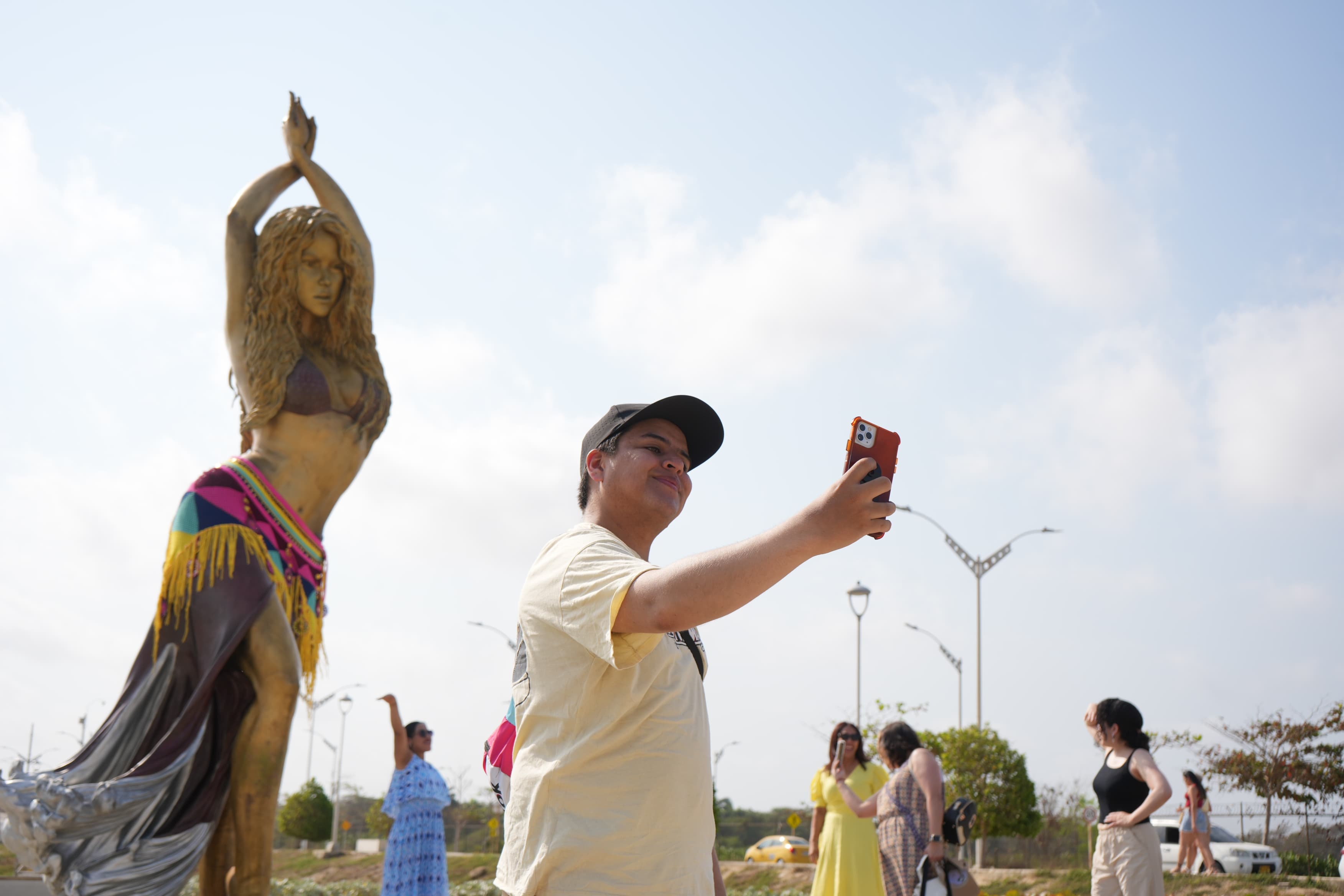 Turista en la estatua de Shakira en el Malecón del Río.