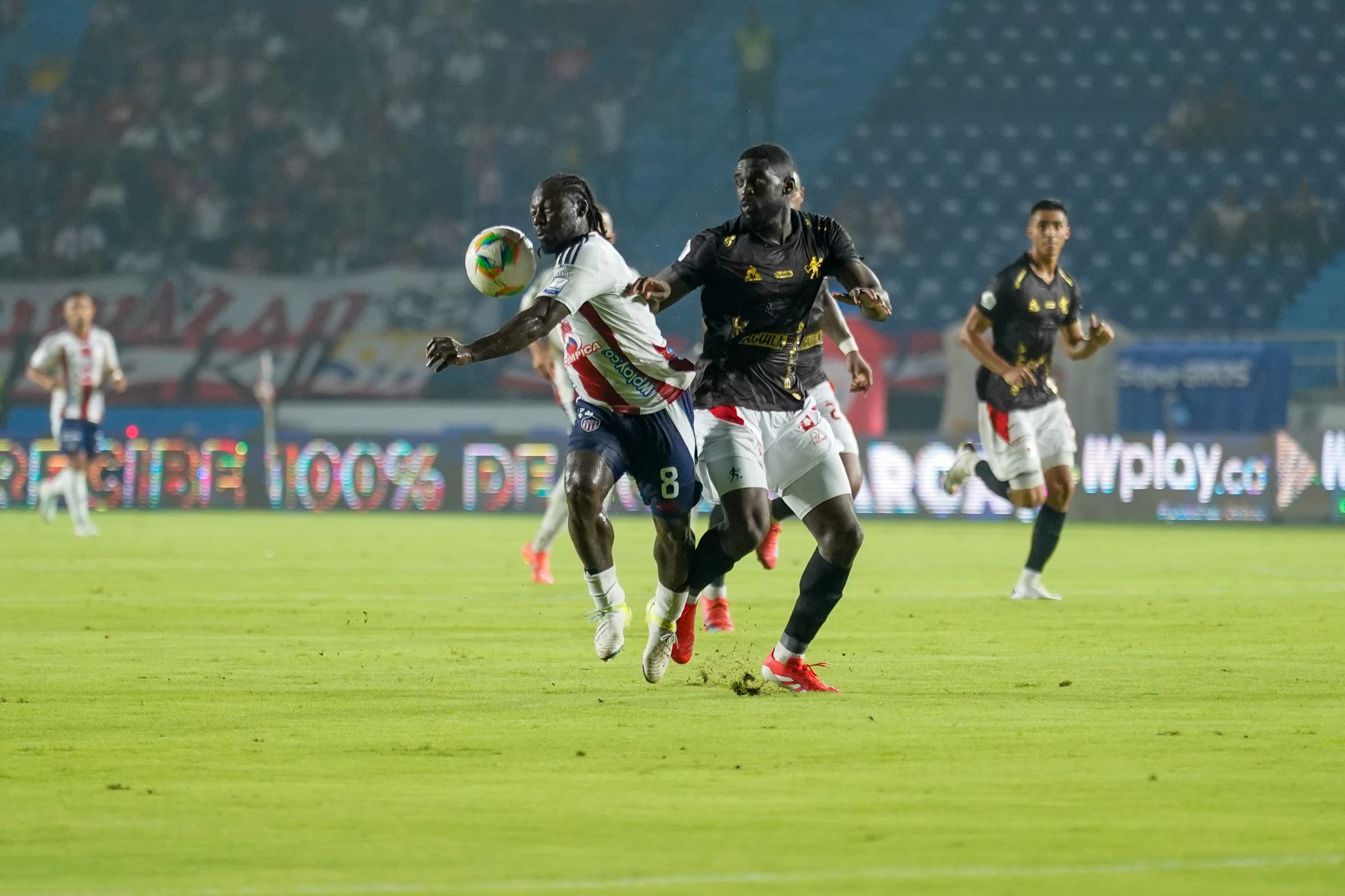 Yimmi Chará disputa el balón con el defensa del América.