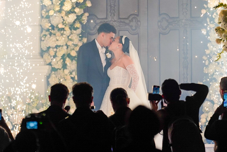 La pareja dándose un beso en las afueras de la iglesia.