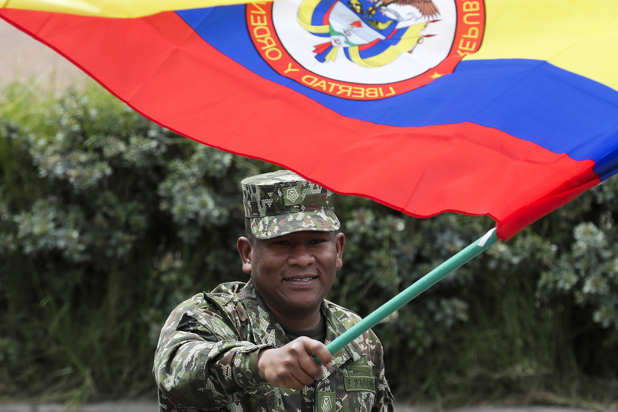 Un integrante de las Fuerzas Armadas sostiene una bandera en el desfile de Independencia.