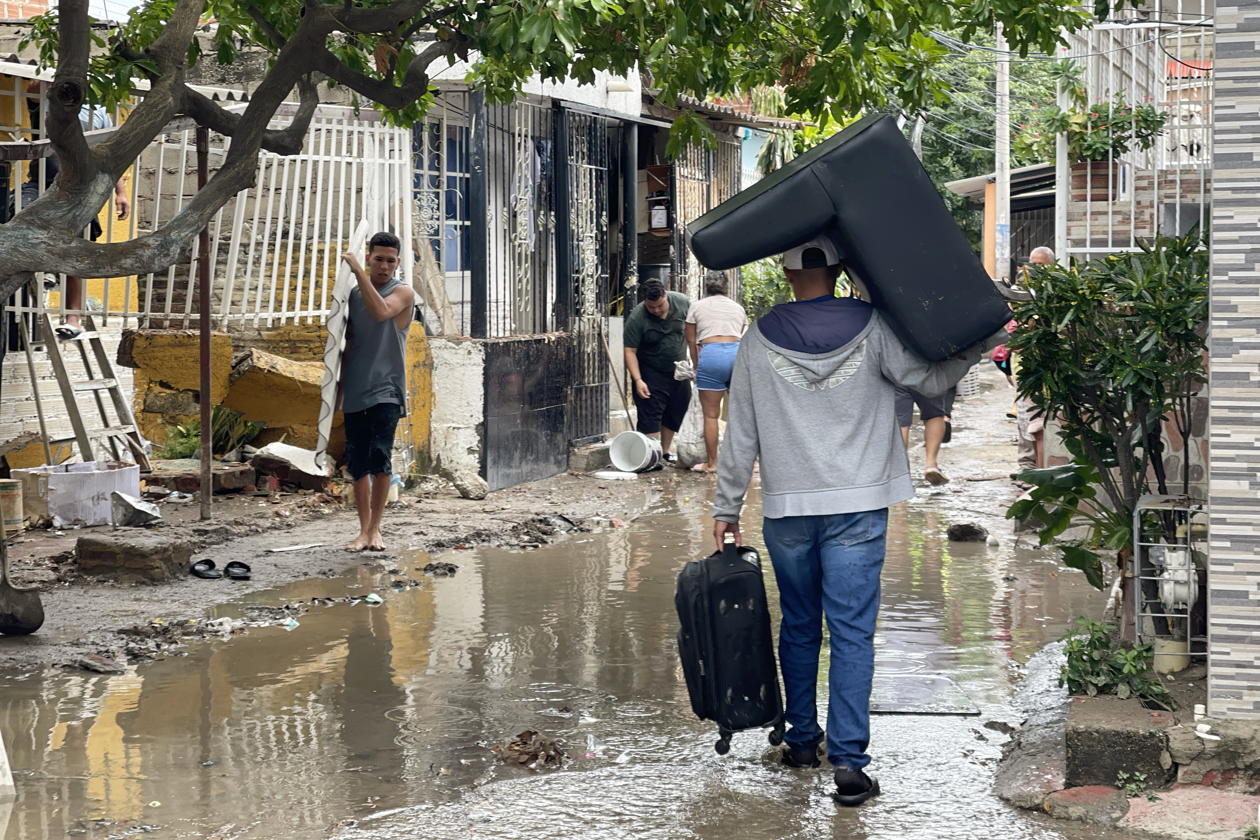 Persona trasladan sus pertenencias en medio de las inundaciones provocadas por las lluvias.