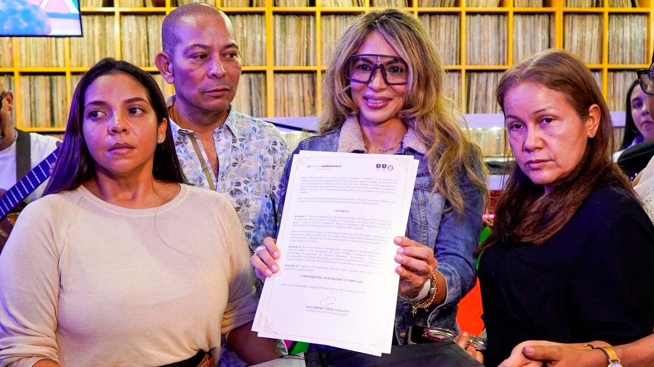 La Gerente de Ciudad Ana María Aljure entrega copia de los decretos a Anamilé Madera y a Darlin Celis.