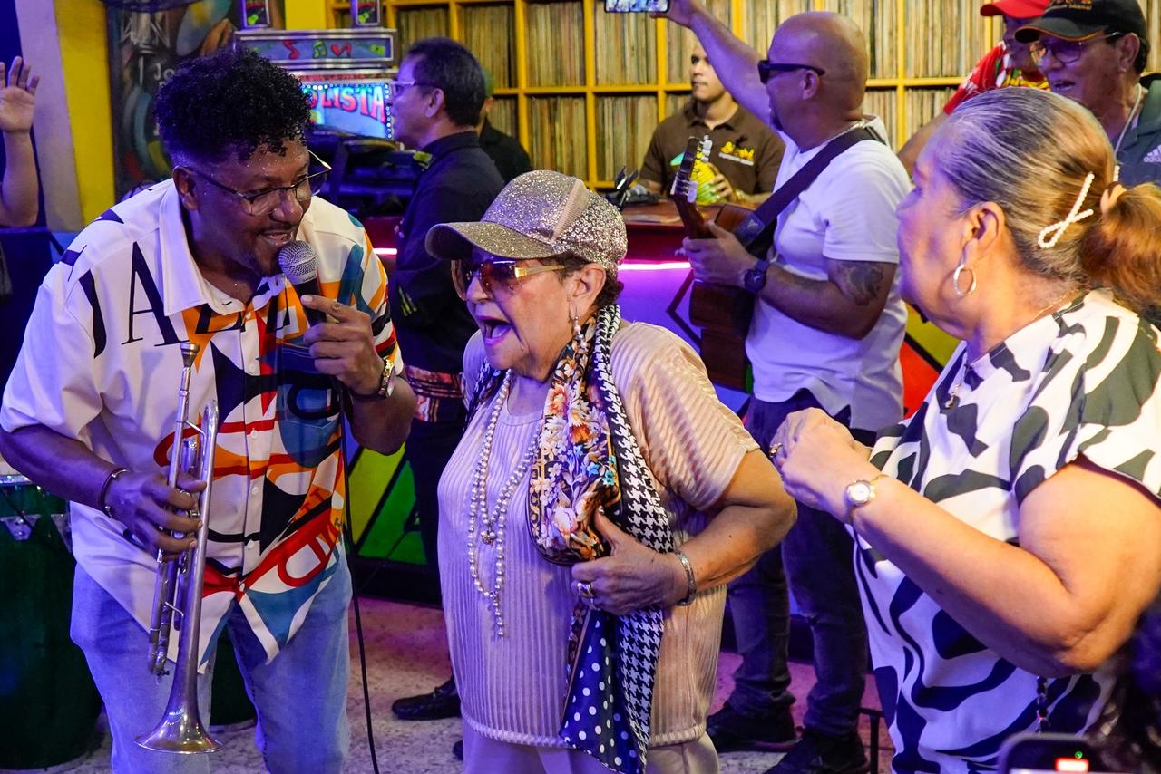 Una trojera de la tercera edad disfruta del 'Son de La Troja', improvisado por el trompeta cubano Pachalo Gavilán.