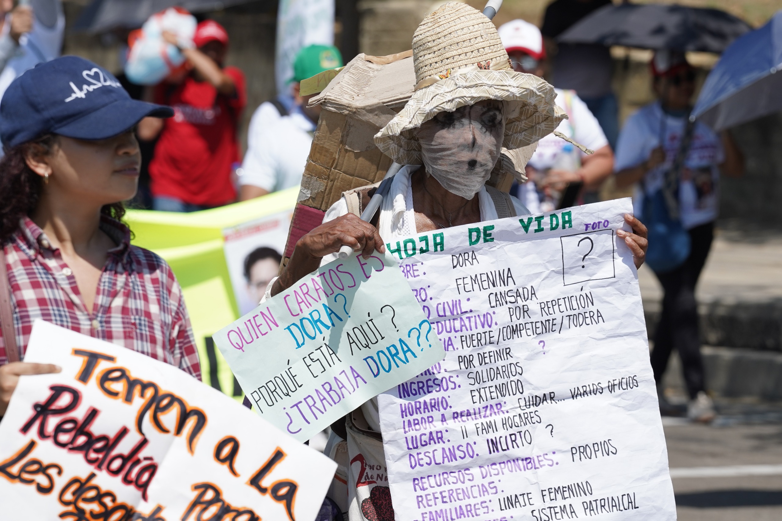Uno de los manifestantes mostrando la hoja de vida de Dora la 'trabajadora'.  