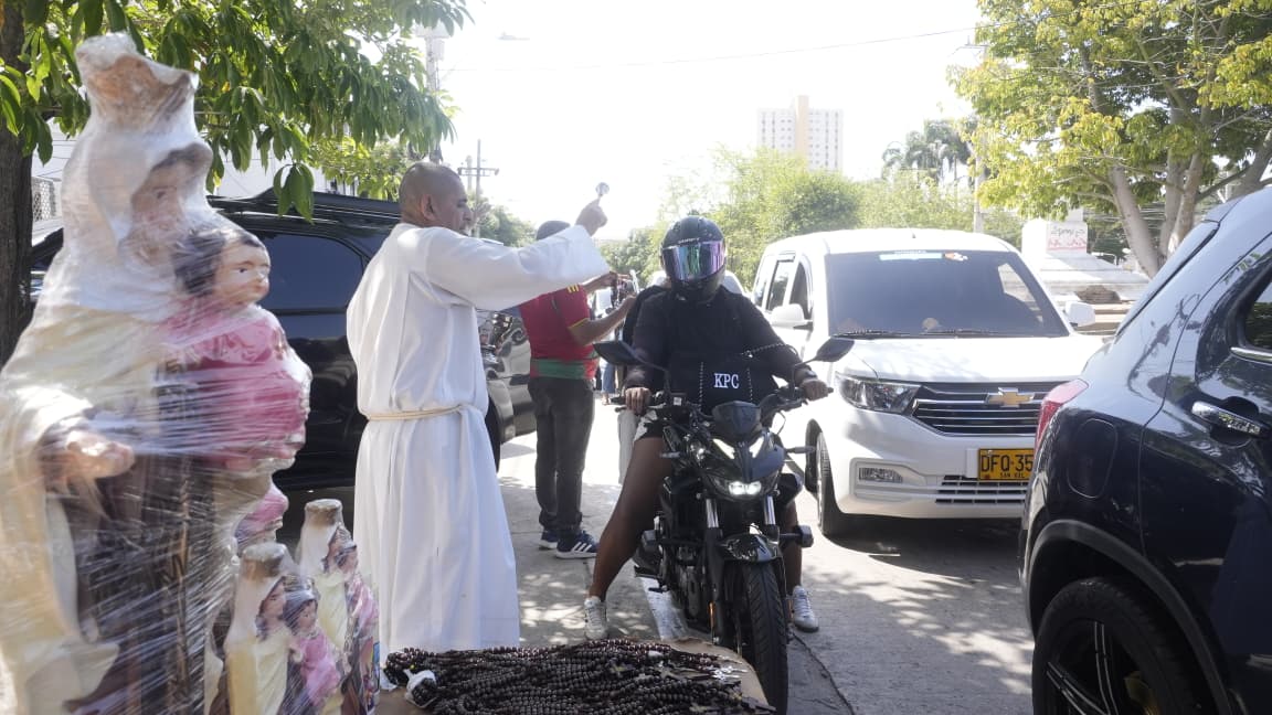  Los feligreses en carros, motos y camiones pasaron por el atrio de la iglesia.