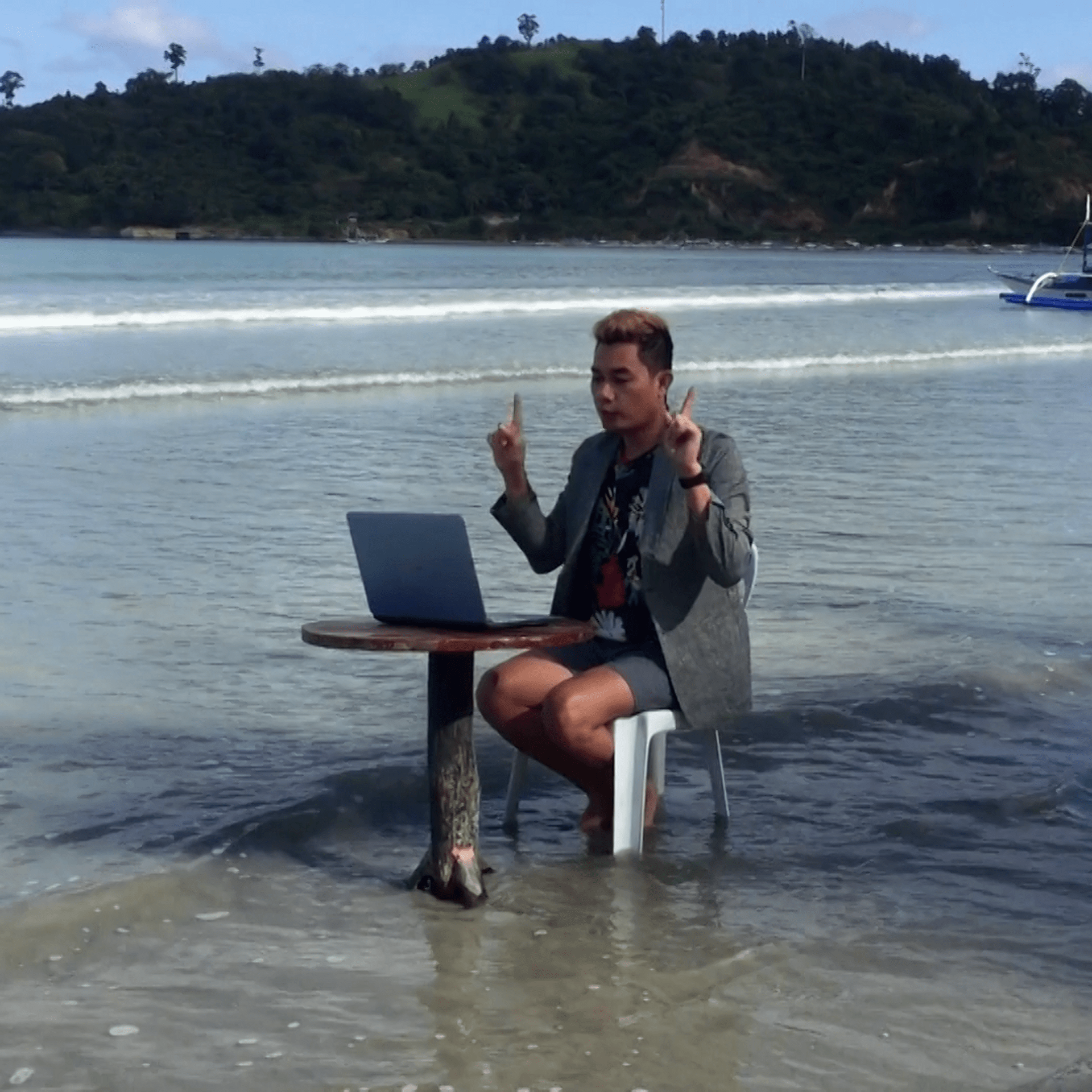 Un profesor dicta clases virtuales en medio de las olas del mar.