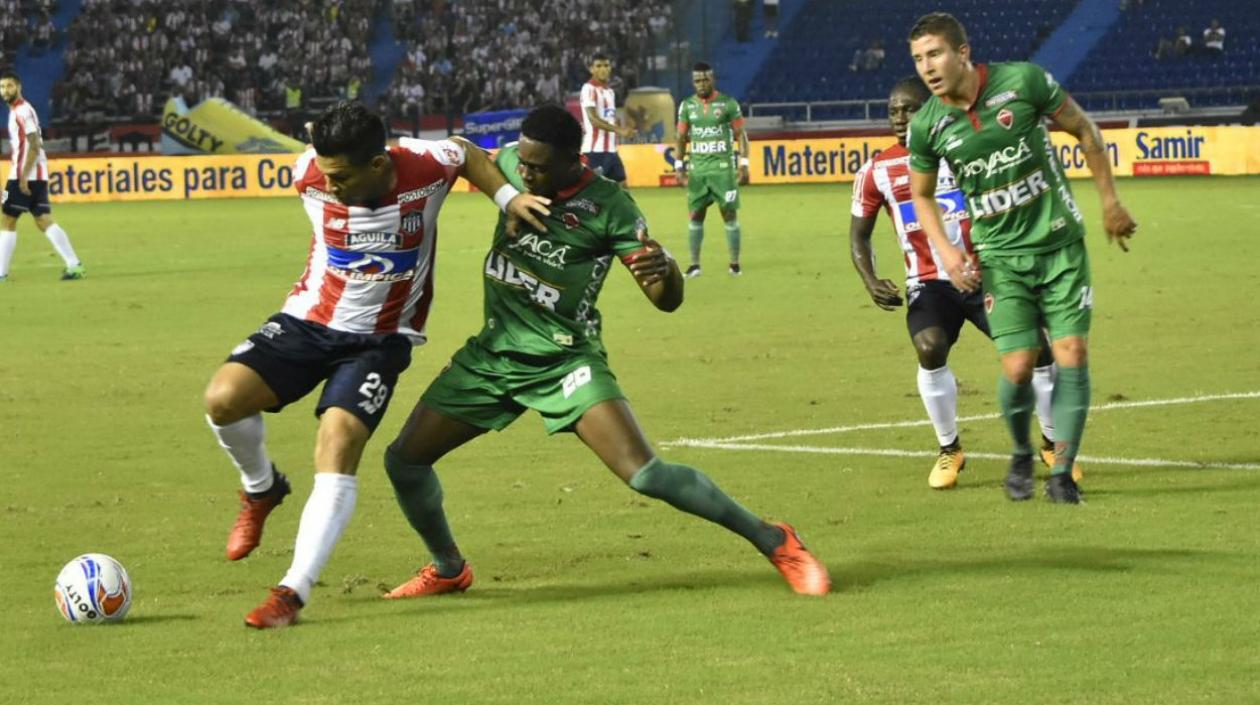 Teófilo Gutiérrez lucha la pelota, atrás Yimmi Chará observa expectante.