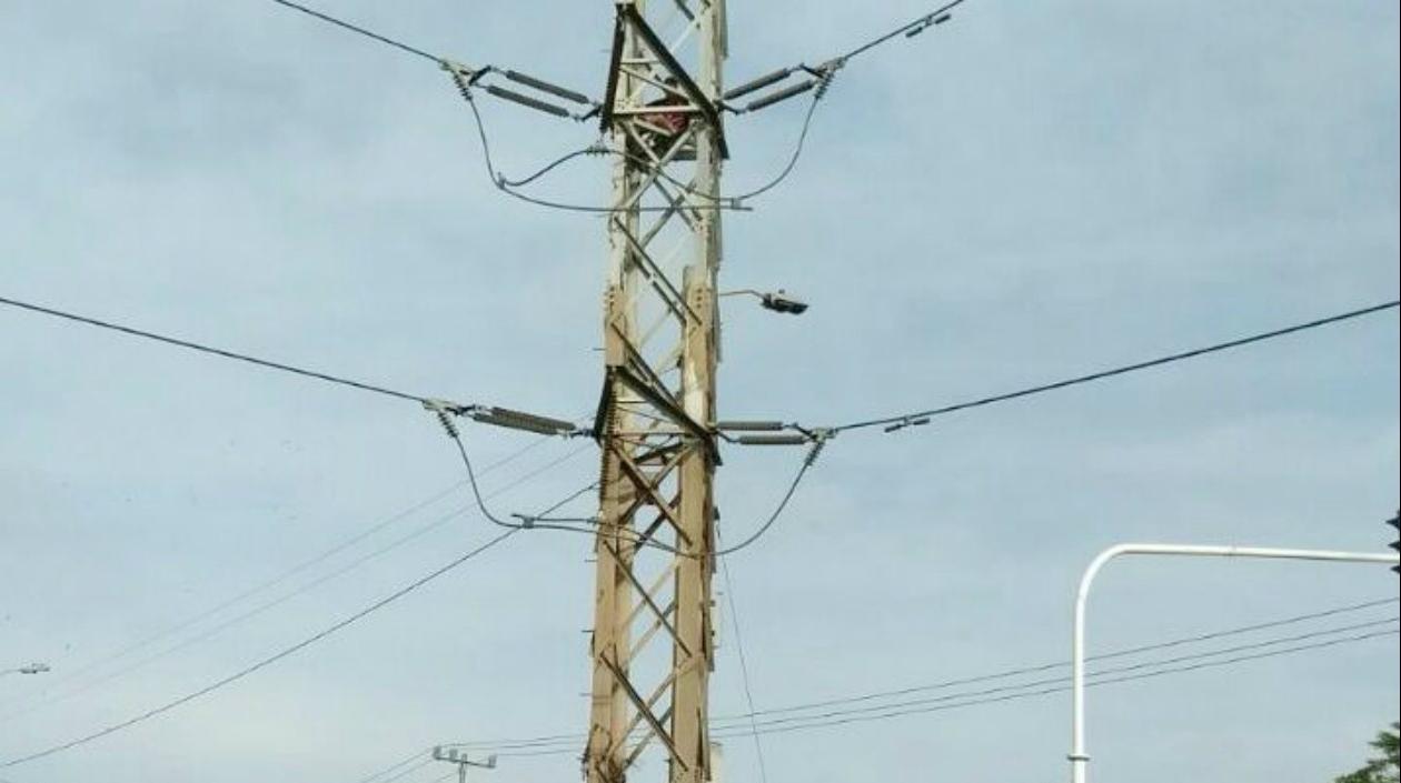 El hombre se sentó en la parte más alta de la torre de energía.