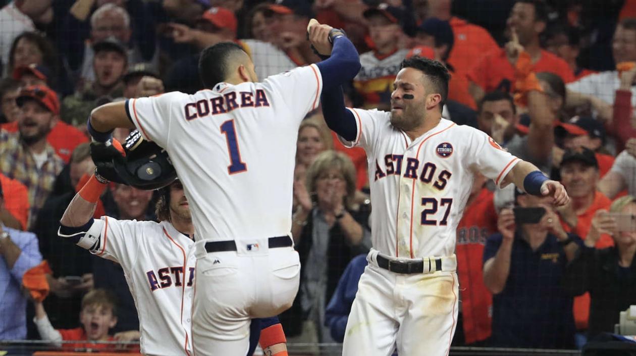 Carlos Correa celebra con José Altuve tras una carrera anotado.