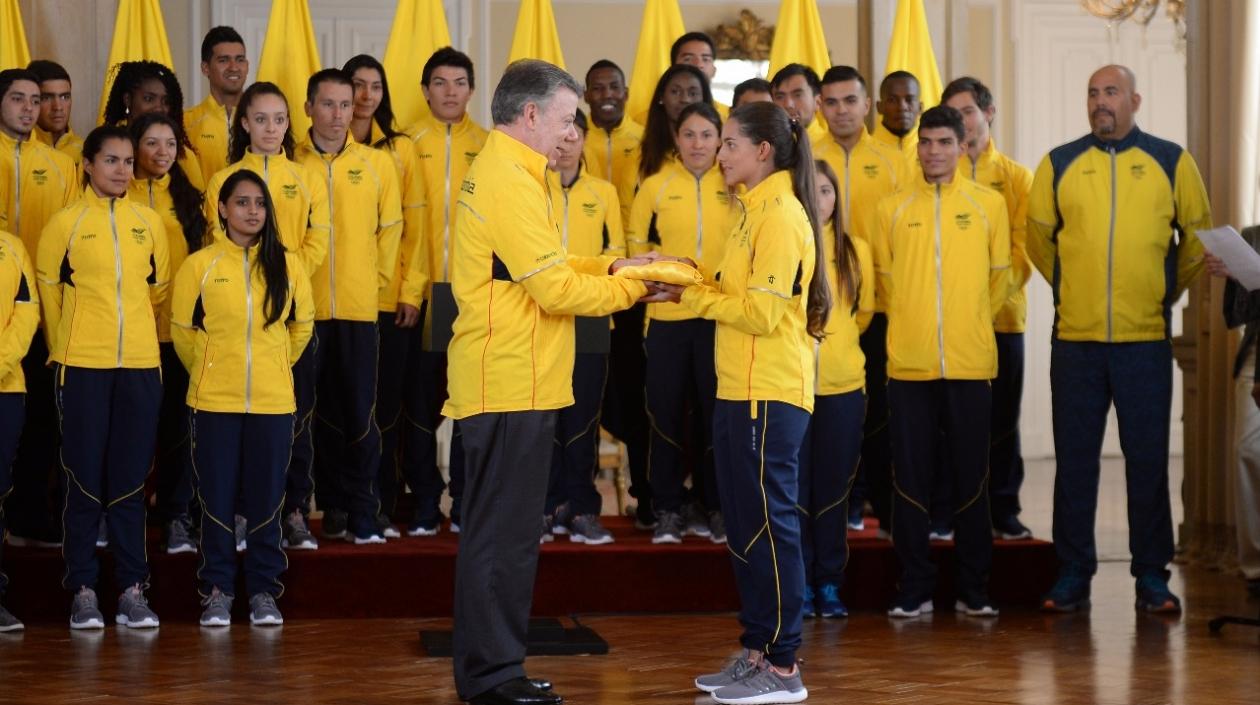 Santos entregando la bandera a Fabriana Arias.