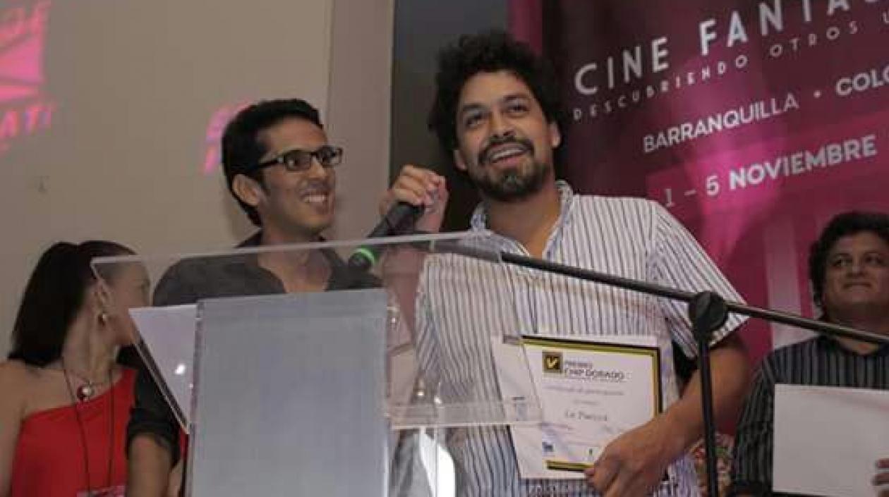 Jorge Ferreira entrega el galardón al cineasta David Aguilera Cogollo.