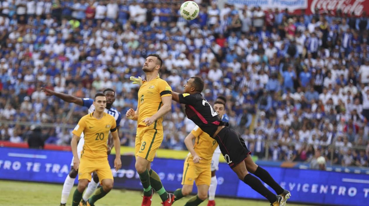 Trent Sainsbury (i) y Bailey Wright (c) de la selección de Australia lucha el balón con el portero Donis Escober (negro) de Honduras