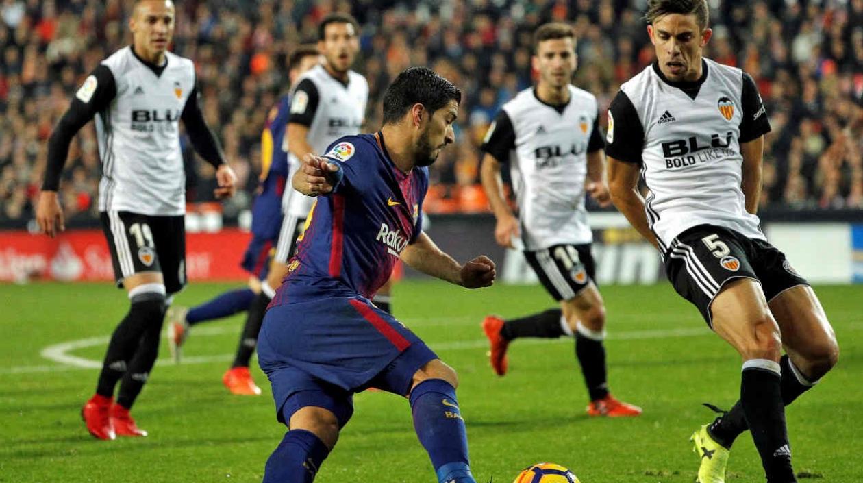 Luis Suárez enfrenta a la defensa del Valencia. 