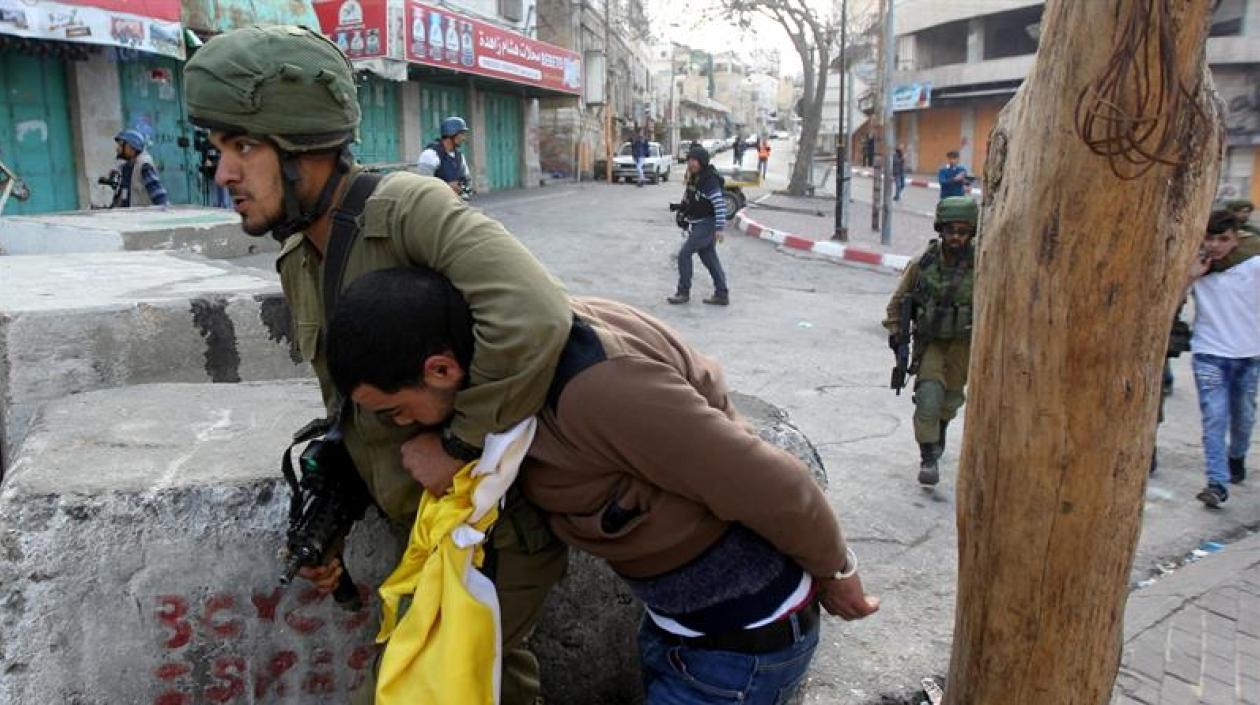 Soldado sometiendo a uno de los manifestantes.