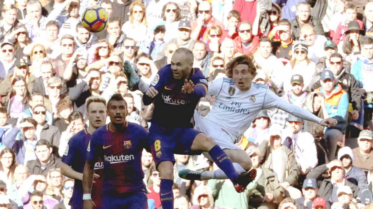 Andrés Iniesta disputa la pelota con Luka Modric.