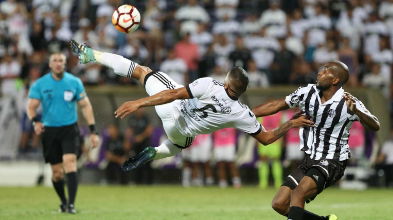  Paulo Lima (d) de Wanderers disputa el balón con Richard Ortíz (i) de Olimpia.