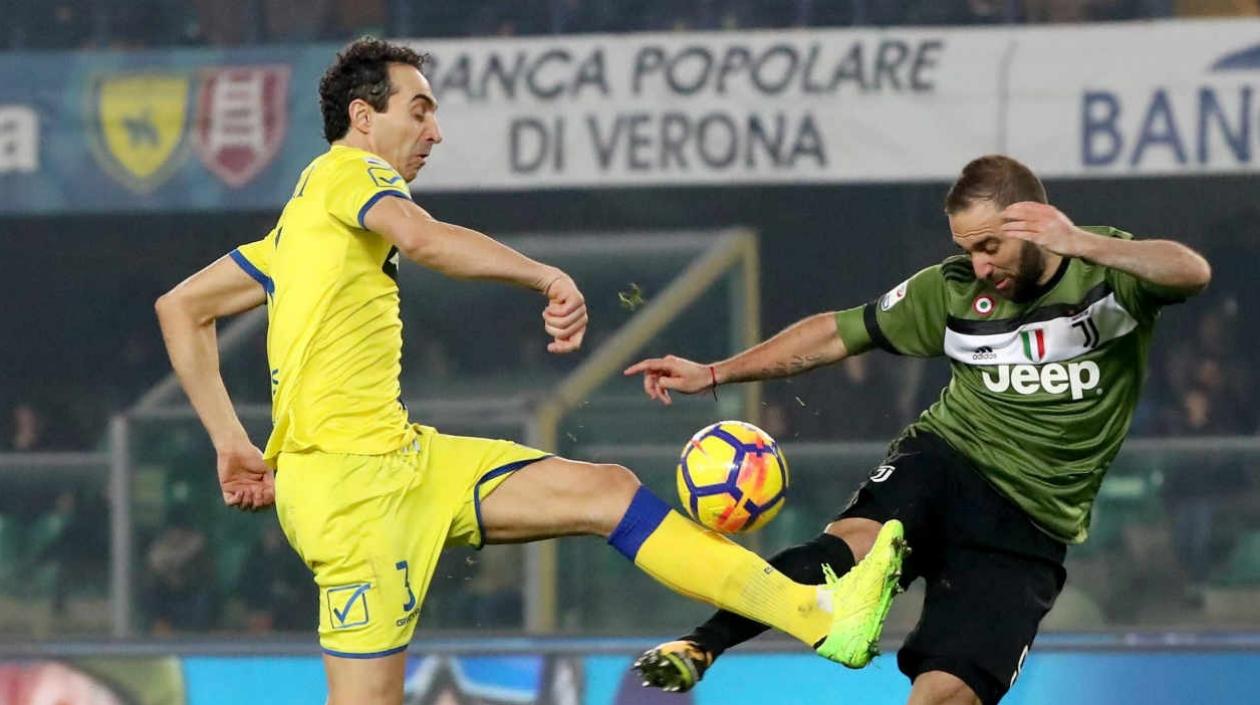 Gonzalo Higuain disputa la pelota con un jugador del Chievo. 
