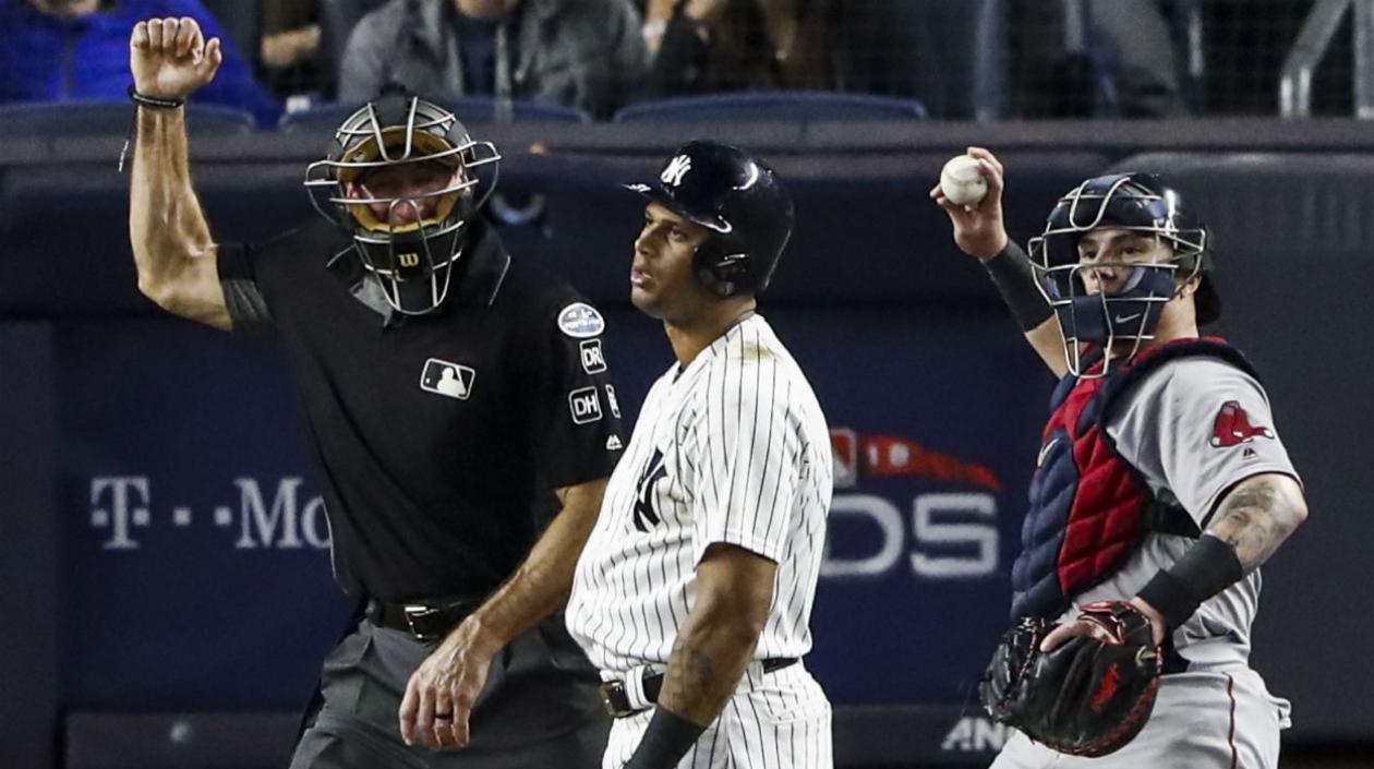 El receptor puertorriqueño Christian Vázquez sostiene la bola, tras que se decretara el ponche sobre Aaron Hicks. 