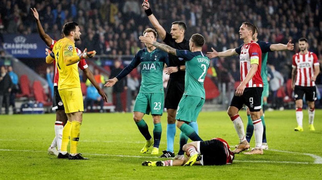 Hugo Lloris (i), portero francés del Tottenham, recibe la tarjeta roja durante el partido disputado ante el PSV correspondiente al grupo B de la Liga de Campeones de la UEFA en Eindhoven, Holanda.